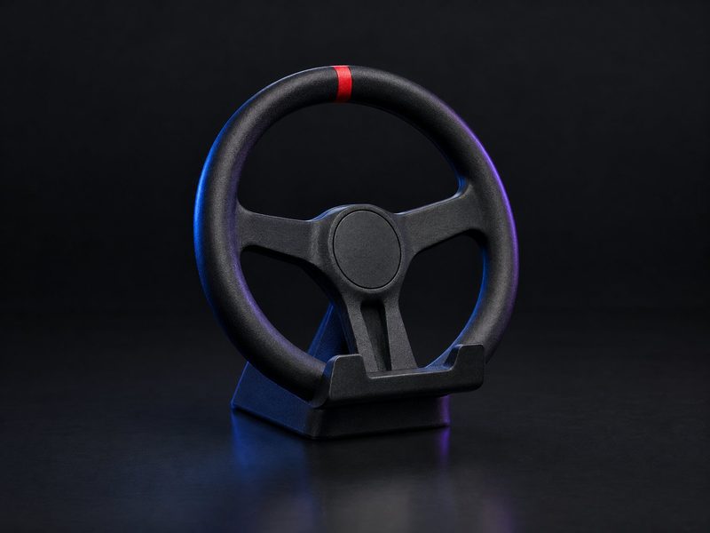 Concept render: Steering-wheel phone stand. A small steering wheel in a desk cradle that holds the phone upright.